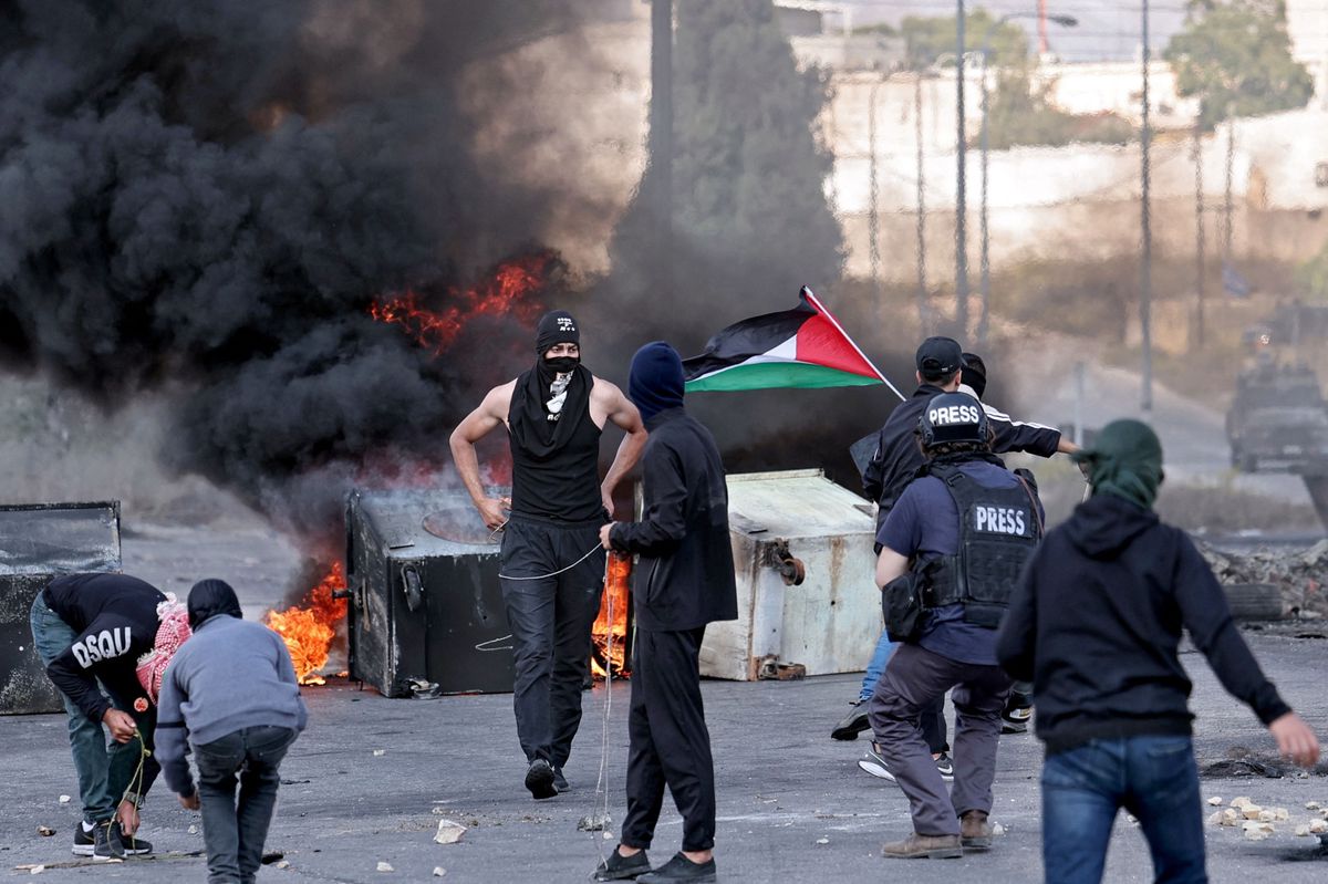 Palästinensische Demonstranten mit Steinschleudern in Ramallah. Mittendrin ein Journalist. 