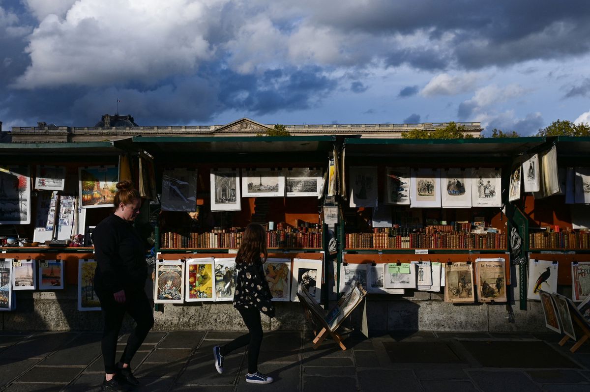 Menschen laufen an den Ständen in Paris vorbei. 