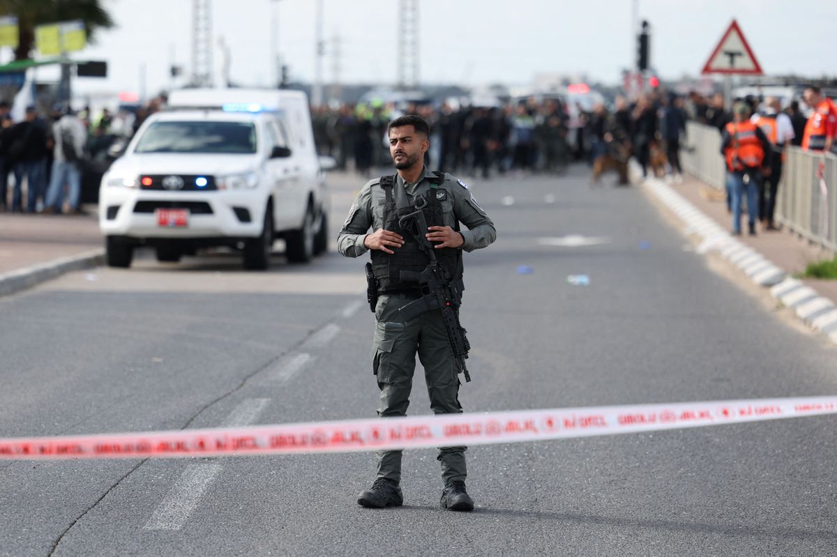 Ein Polizeibeamter sichert nach dem Angriff im Süden Israels die Strasse. Im Hintergrund sind weitere Polizisten und Ersthelfer zu sehen. (16. Februar 2024)