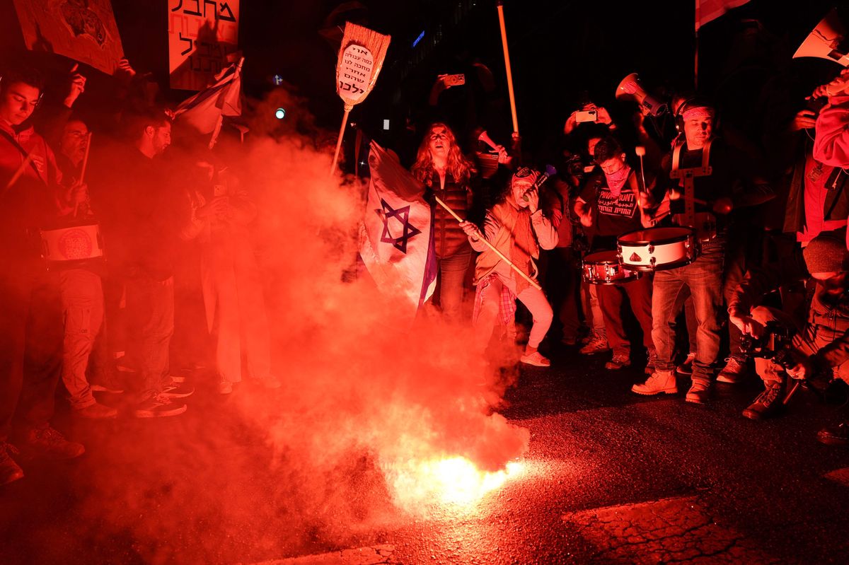 Demonstranten in Tel Aviv stehen auf einer Strasse um brennende Fackeln herum. (17. Februar 2024)