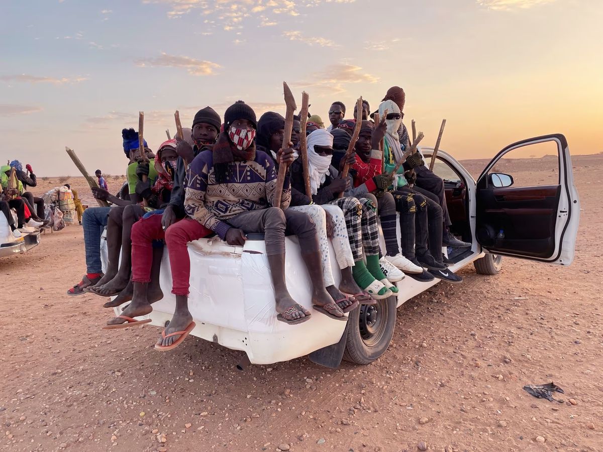 Reise Richtung Wüste, Richtung Hoffnung. Winddicht verpackte Flüchtlinge sitzen auf der Ladefläche von Pick-ups. Ihr einziger Halt sind lange Stöcke.