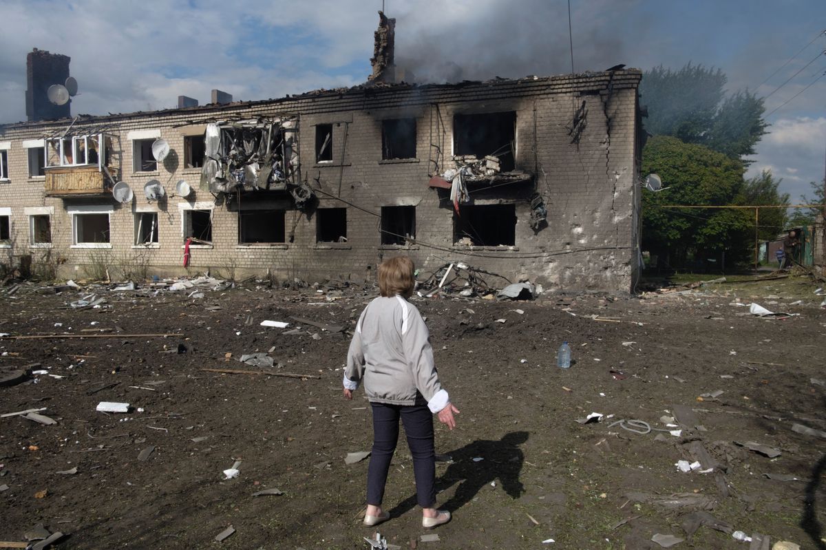 Eine Ukrainerin vor einem durch russische Luftschläge beschädigtes Haus in der Region Charkiw, 11. Mai 2024.